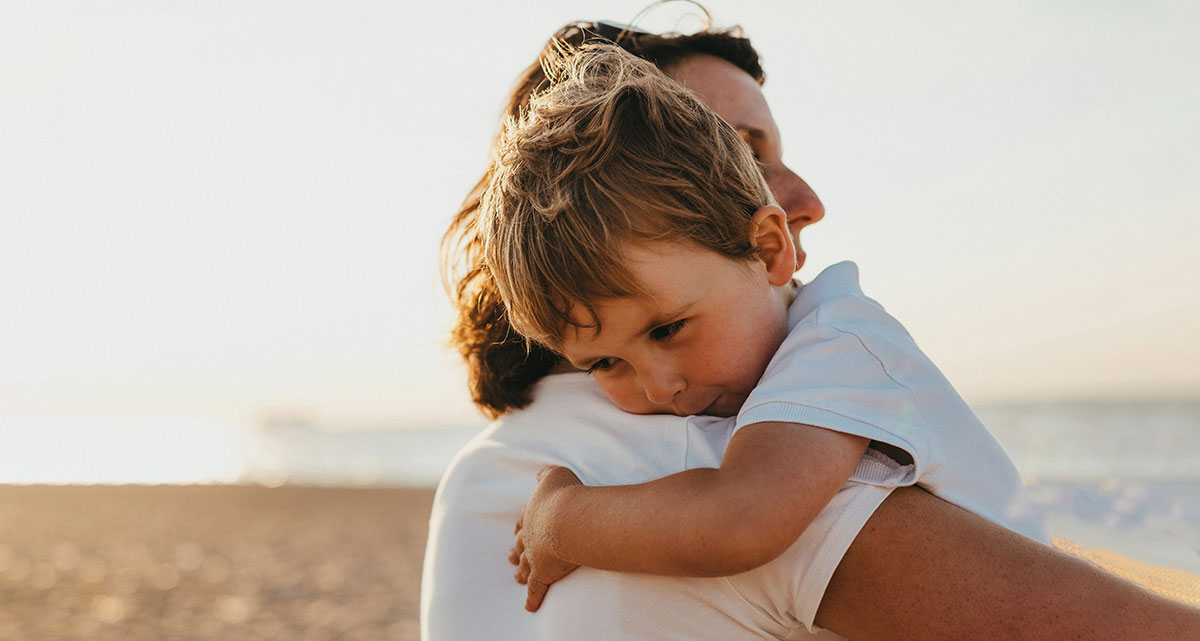 une mère serrant son enfant dans ses bras